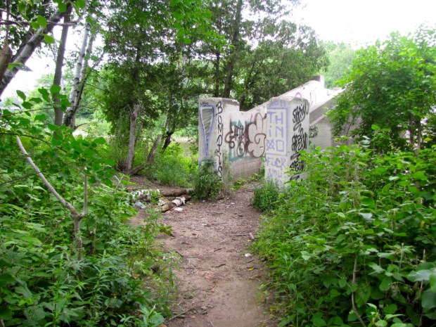 With its muddy trail, litter, graffiti on every conceivable surface, and stairs leading to a walkway across the gated section of the dam, the island isn't much to look at. Whoever ends up owning this island might consider tidying it up a bit. Photo by Carl Swanson